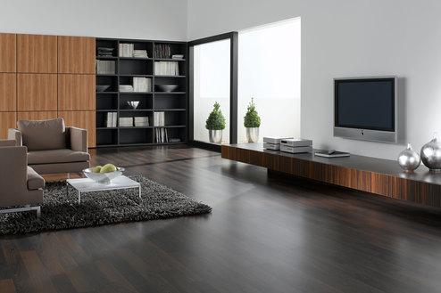 Wohnraumimpression mit dunklem Mobiliar Wohnraumimpression mit verschieden dunklen Holzoberflächen für Einbauschrank, Sideboard und Bodenbelag